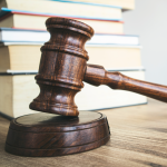 A gavel and books in the background